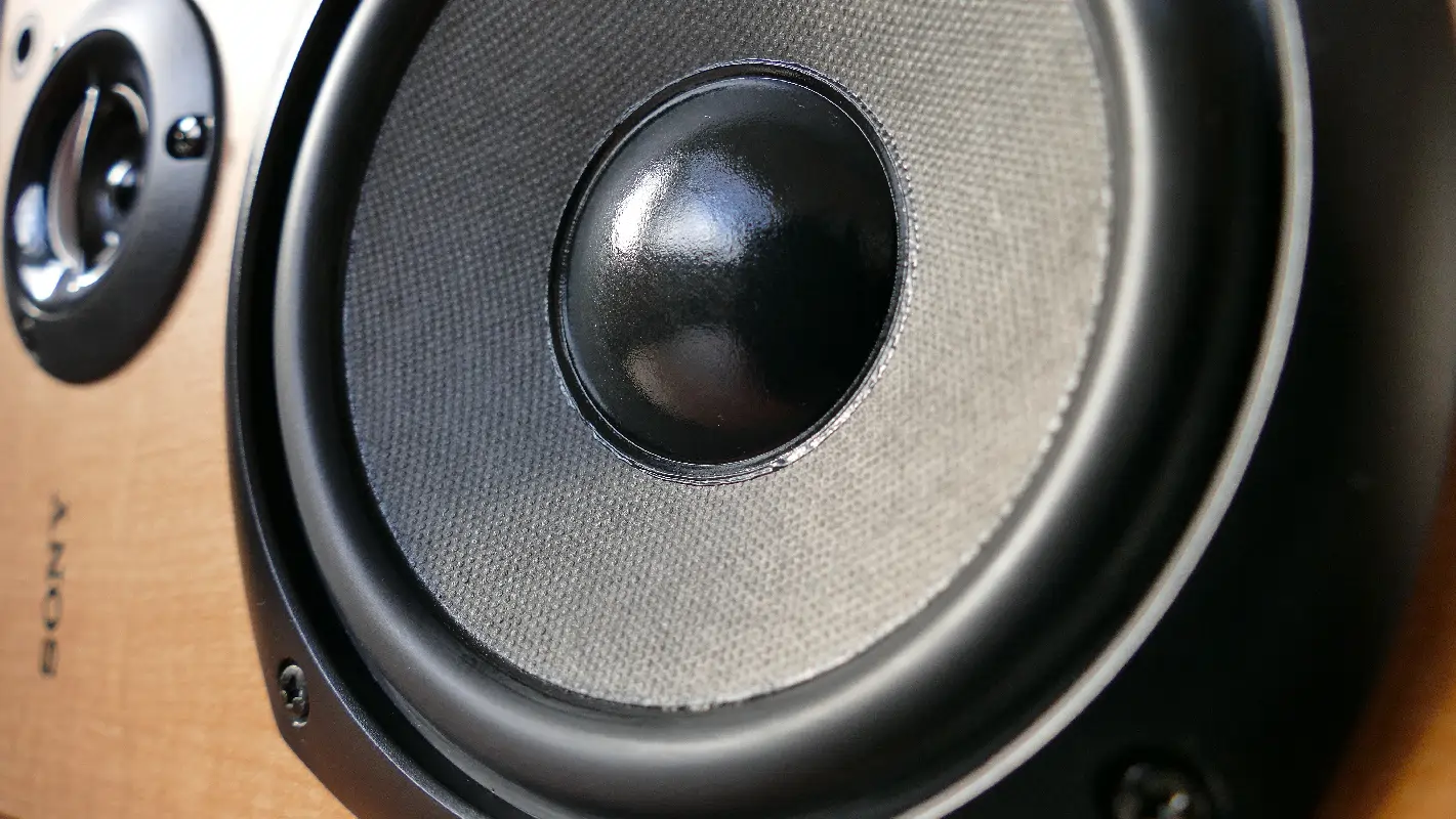 Close up of a high quality speaker driver in a wooden cabinet